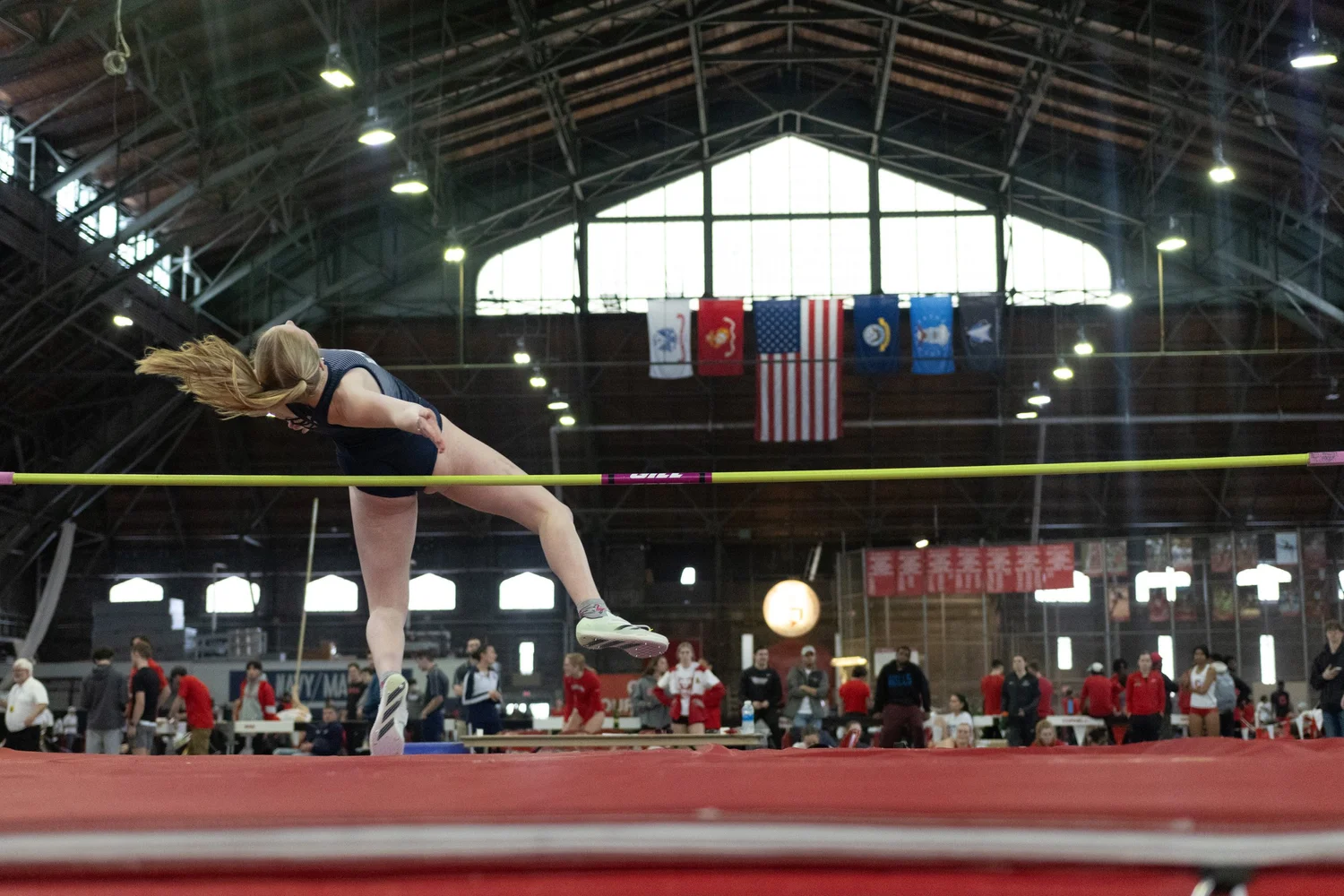 Photo of Ithaca College athlete on high jump at a track meet at Cornell University.