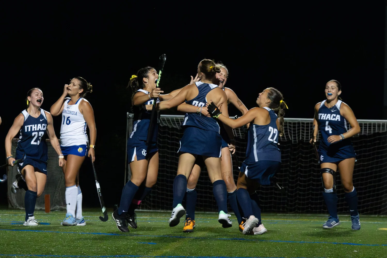 Photo of the Ithaca College field hockey team celebrating a goal.